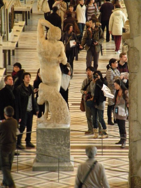  visiteurs du Louvre devant une sculpture